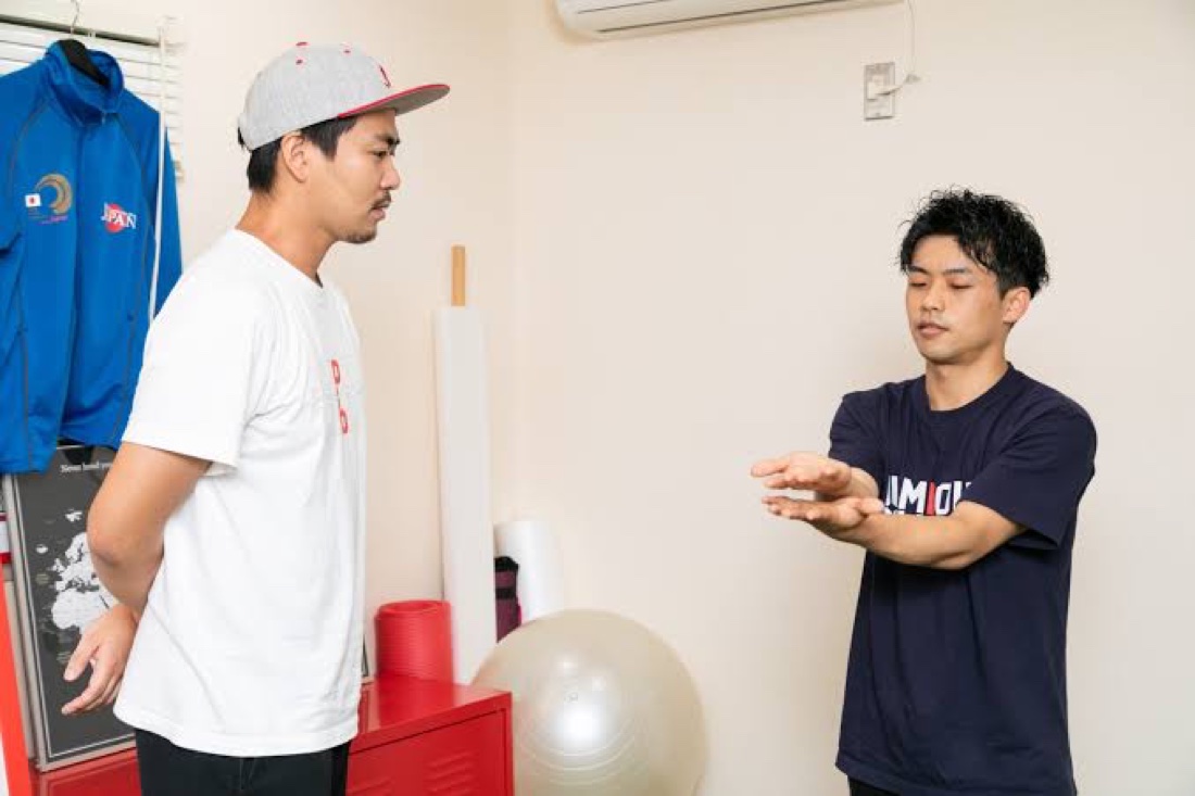 日本代表ウェアでアスリートに動作を指導する様子